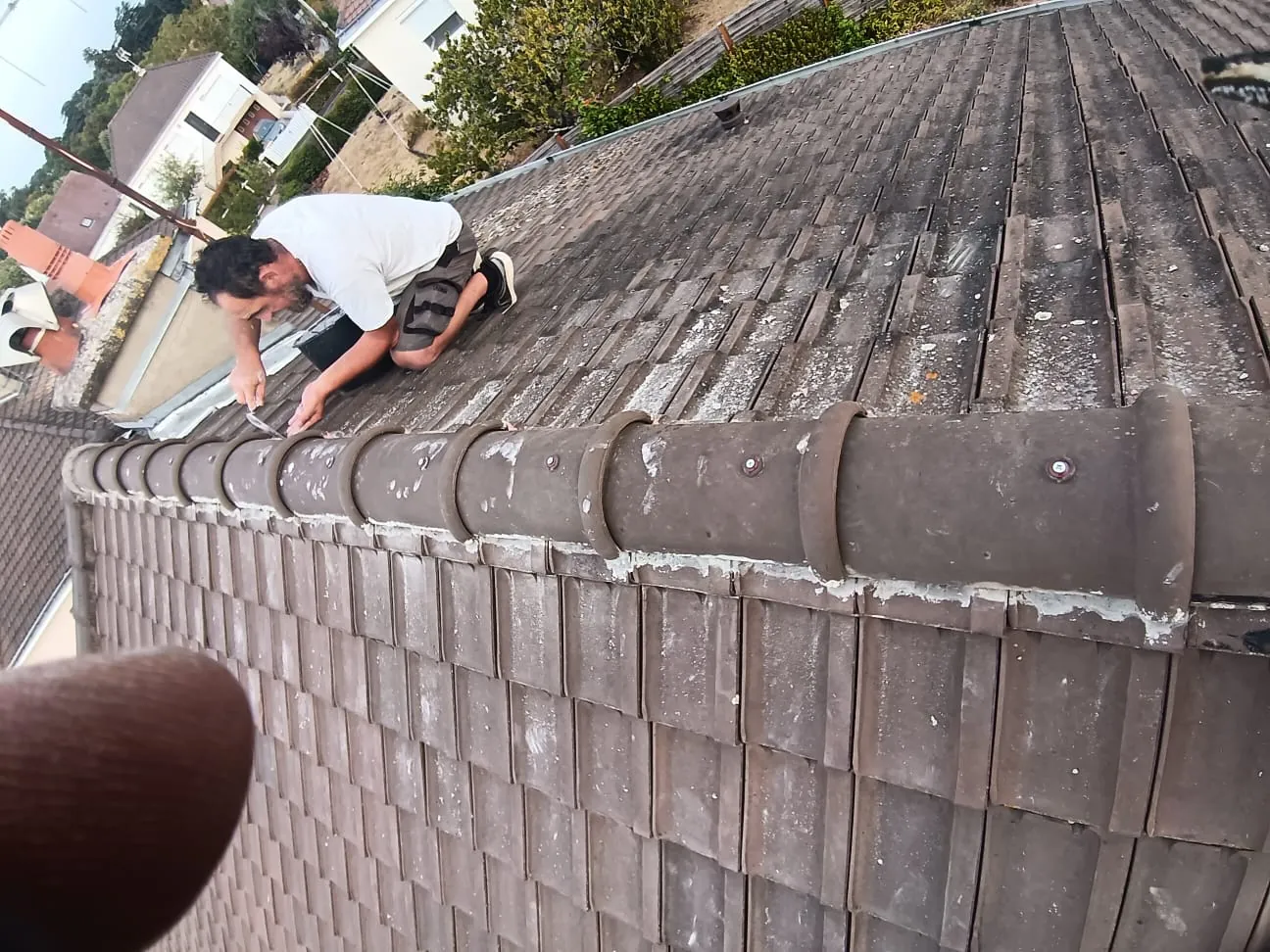 Scellement du faîtage au mortier sur une couverture en tuile, en cours de réfection