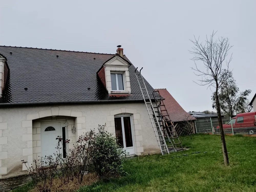 Échelles de toit installées le long d'une couverture en ardoise avant intervention